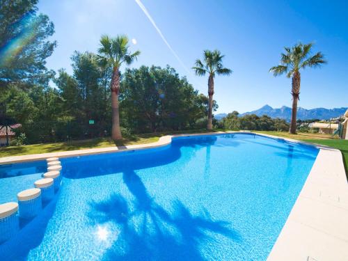 维耶亚高原Apartment Villa Marina Golf-1 by Interhome的一座棕榈树和山脉环绕的游泳池