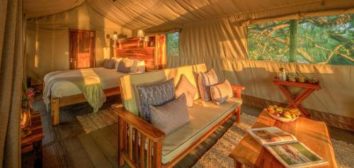 ShakaweXaro Lodge的一间卧室配有一张床和一个沙发