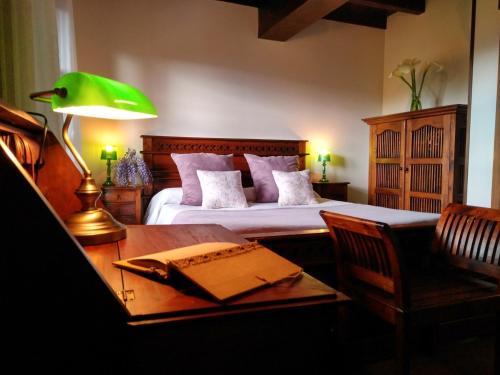 UdiasPosada Sel de Breno的一间卧室配有一张带书桌和绿灯的床。