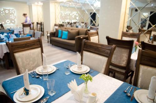奇姆肯特Luxury House的一间配备有桌椅及蓝桌布的用餐室