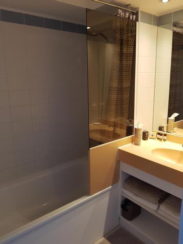 泰晤勒·苏尔·梅尔Le 332 Vue Panoramique Mer, Piscine, Garage Privatif的带浴缸、水槽和镜子的浴室