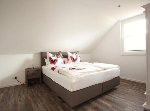 布莱特瑙Ferienhaus am Rösslewald的一间卧室配有一张带白色床单的床和一扇窗户。