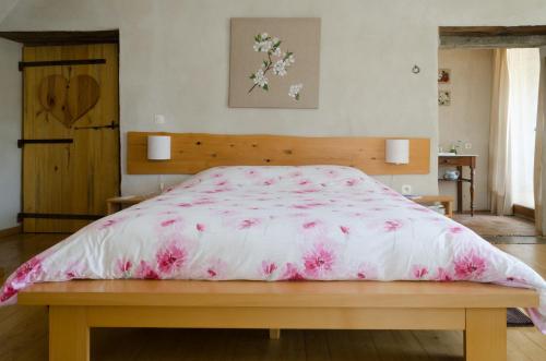 圣安德烈-德瓦尔博涅Cocon des Cévennes - Pierre de Lune的一间卧室配有一张带粉红色棉被的大床