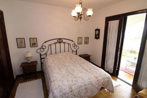 莫甘Lovely 2 bedroom house with private garden的一间卧室配有一张床和一个吊灯