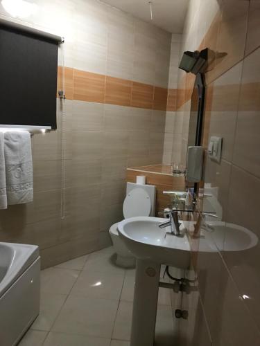 阿克拉禁区酒店的浴室配有白色水槽和卫生间。