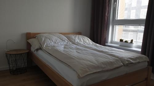 华沙Quo Vadis Apartment的卧室内的一张未铺好的床,设有窗户