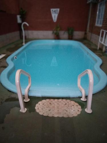 伊瓜苏港Petit Hotel Panambi的游泳池中间有两把手