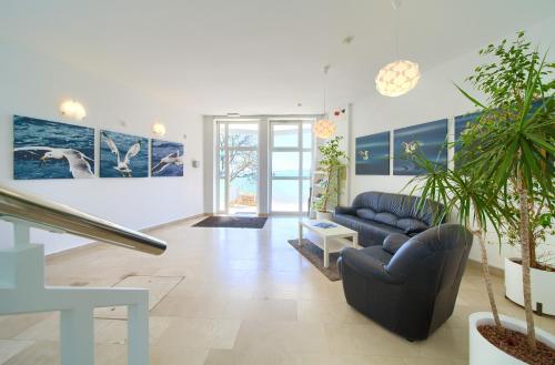 克尔克Villa Tamaris - Hotel Resort Dražica的客厅配有蓝色沙发和一些植物