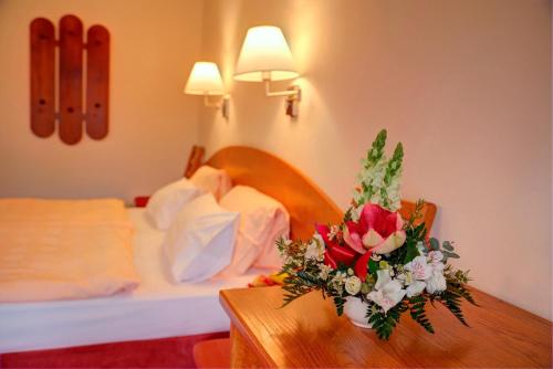 普鲁洪尼斯普鲁洪尼斯公园酒店的酒店客房设有一张桌子,上面摆放着鲜花