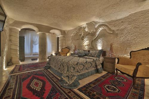 格雷梅Kayatas Cave Suites的一间大卧室,配有一张石墙床