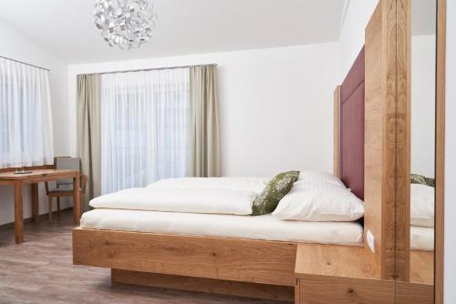 AngernWeinhof - Gästehaus Maier的一间卧室配有一张带木制床头板的床