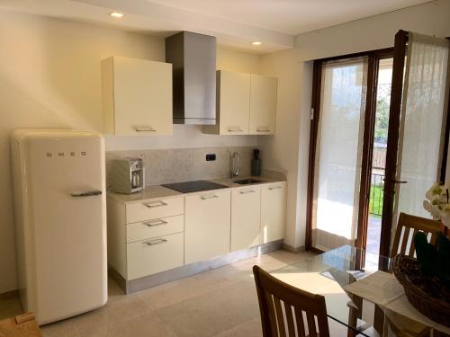 阿科Appartamenti Villa Sonia的厨房配有白色橱柜和白色冰箱。