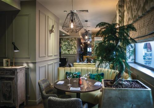 考文垂Ramada Hotel & Suites by Wyndham Coventry的一间设有桌子和盆栽的饭厅