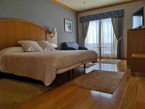 阿兰扎达萨马酒店的一间卧室设有一张大床和大窗户