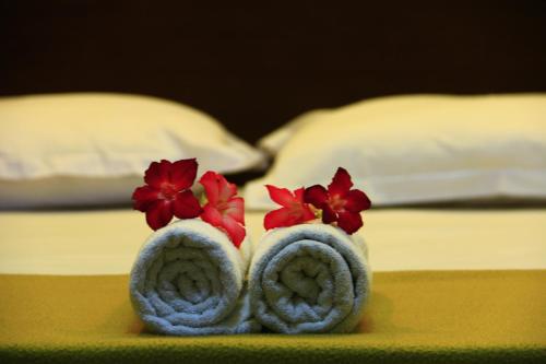 库塔纳库拉酒店的床上一双带红色鲜花的毛巾