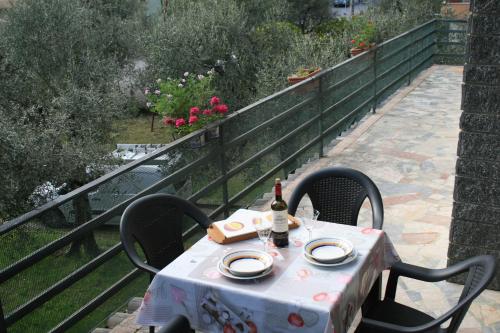 托斯科拉诺-马德尔诺La terrazza sugli ulivi的一张桌子、两把椅子和一瓶葡萄酒