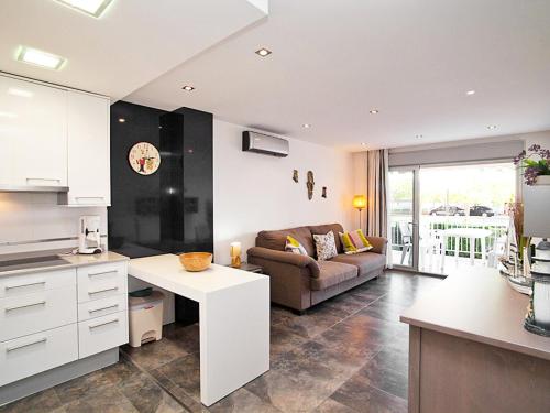 维拉福林Apartment DMS V by Interhome的厨房以及带沙发和桌子的客厅。