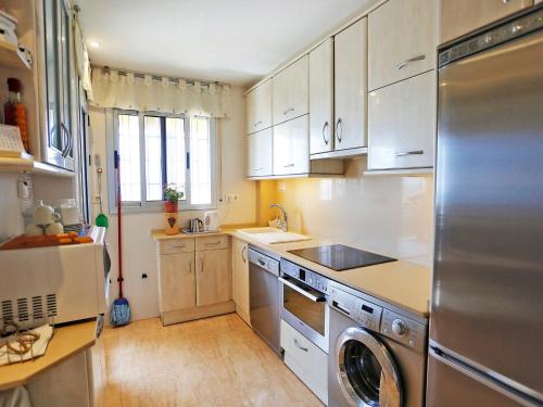 维拉福林Apartment Lekeitio-1 by Interhome的厨房配有白色橱柜和不锈钢冰箱