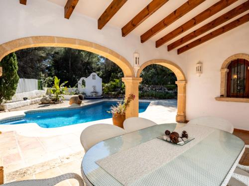 贝尼塔切利Holiday Home Amadorio by Interhome的一个带桌椅的庭院和一个游泳池