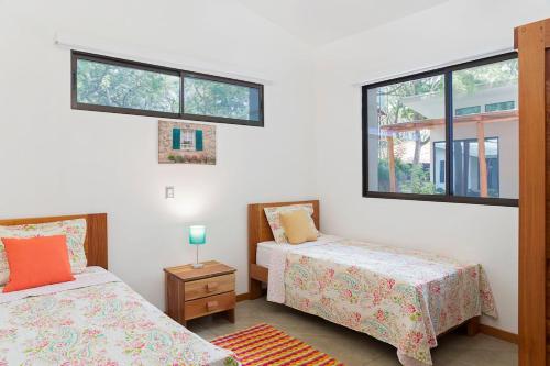 里瓦斯Eco Casita 11的一间卧室设有两张床和两个窗户。