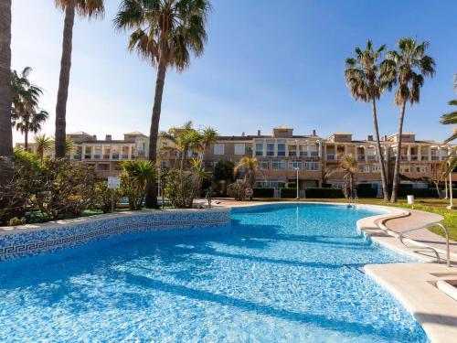 德尼亚Apartment La Rosaleda-3 by Interhome的一座棕榈树游泳池和一座建筑