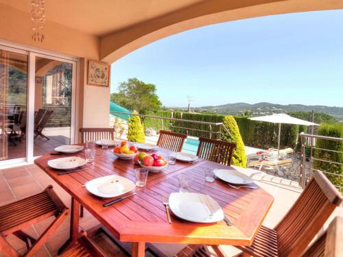 卡隆赫Holiday Home Mas Ambros by Interhome的天井上的木桌,享有阳台的景致