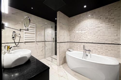 布斯克·兹德鲁伊苏维兹尼兹德鲁伊医疗温泉疗养酒店的浴室设有白色浴缸、水槽和镜子