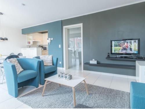 布列登Apartment Residentie Duinenbries-1 by Interhome的客厅配有蓝色的沙发和电视