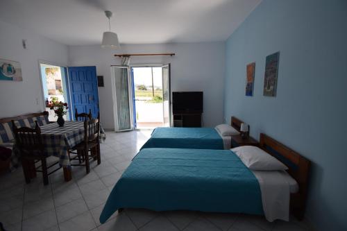 纳克索斯岛卡斯特拉基Palmos Self-Catering Apartment的一间带两张床的卧室和一间带桌子的用餐室