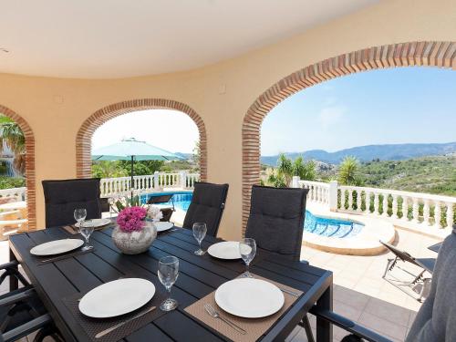 蒙特佩戈Villa Capi by Interhome的一间带桌椅的用餐室和一个游泳池