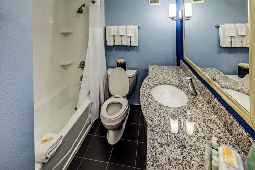 门托克利夫兰东北 - 门图尔假日酒店的浴室配有卫生间、盥洗盆和浴缸。