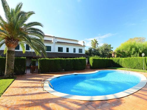 坎布里尔斯Holiday Home Calderon de la Barca by Interhome的一座棕榈树和房子的游泳池