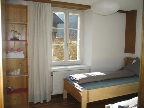 沃尔芬希森Apartment Villa Alpenblick Wolfenschiessen by Interhome的一间卧室设有一张床和一个窗口
