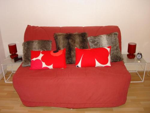 图尔吉特乐尔米塔格酒店的红色的沙发,配有红色和白色的枕头