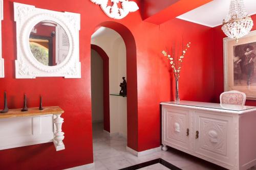 EsteponaFamily hotel Al- Ana Marbella的红色的房间,配有白色的橱柜和镜子