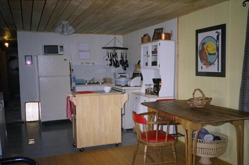 怀特霍斯B的三次方住宿加早餐酒店的厨房配有桌子和白色冰箱。