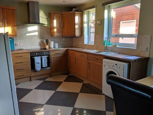 特尔福德Avon House的厨房设有木制橱柜和 ⁇ 格地板。