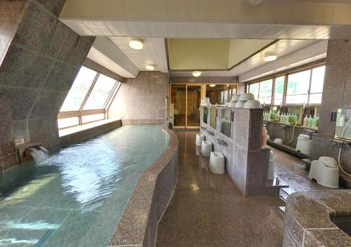松山松山入住酒店的大型浴室设有大型游泳池