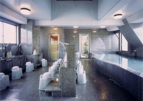 松山松山入住酒店的大型浴室设有游泳池、水槽和卫生间