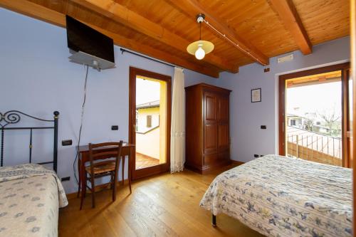 MedeaAgriturismo Lis Rosis的一间卧室配有两张床和一台平面电视