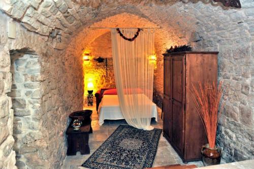 焦维纳佐Corte Sagarriga Visconti的卧室配有一张石墙床