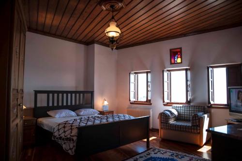 马克里尼撒Traditional Mansion Calliopec-UVC sterilized的一间卧室配有一张床、一把椅子和窗户。