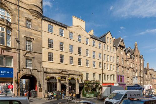 爱丁堡Destiny Scotland - Royal Mile Residence的城市街道上一座大型建筑,有汽车