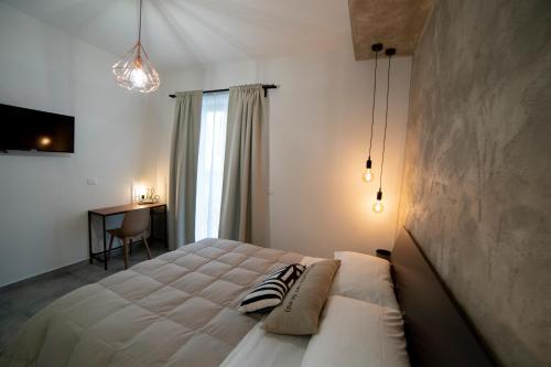 扎费拉纳-埃特内阿Anna & Alfredo bed and breakfast的卧室配有一张白色大床和一张书桌