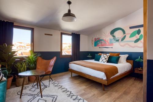 里斯本Selina Secret Garden Lisbon的卧室配有一张床和一张桌子及椅子