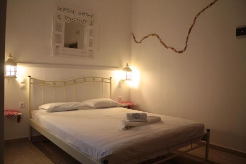 皮特斯迪亚Olympias Studio "Pitsidia"的卧室配有白色床,墙上挂着风筝
