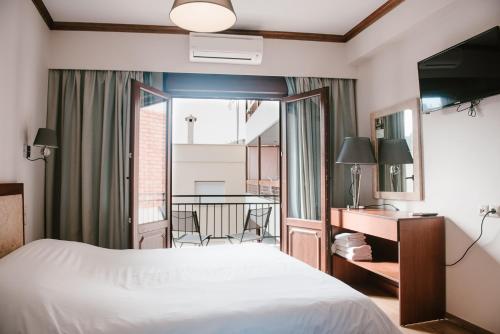 约阿尼纳肯翠康酒店的酒店客房设有一张床和一个阳台。