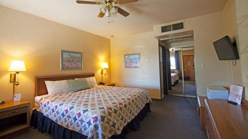 博尔德城El Rancho Boulder Motel的酒店客房配有一张床和吊扇。