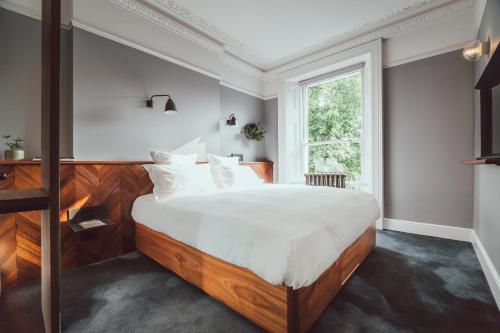 伦敦朝圣者酒店的一间卧室设有一张大床和一个窗户。