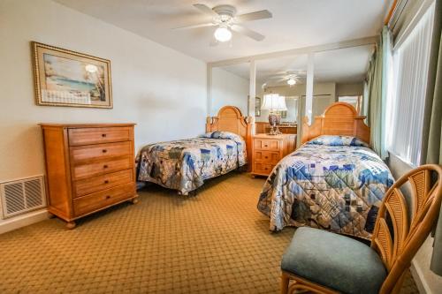 圣徒皮特海滩珊瑚礁度假酒店，VRI度假村的一间卧室配有两张床、一个梳妆台和镜子